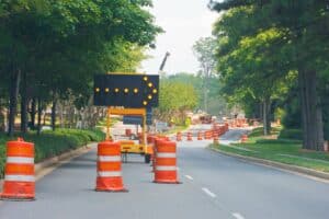 trees near a road that has construction cones