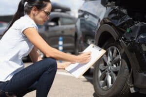 Woman taking notes on clip board of accident