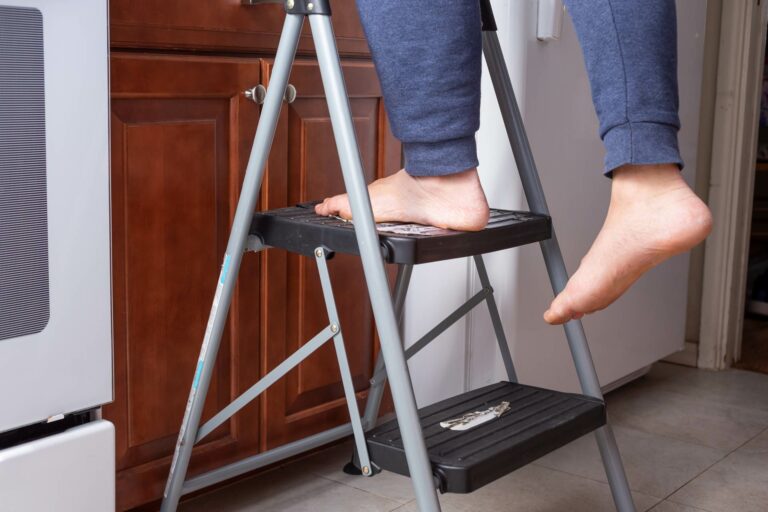 Close-up view of a person on a stepladder with no shoes | product liability | NBF Accident Law